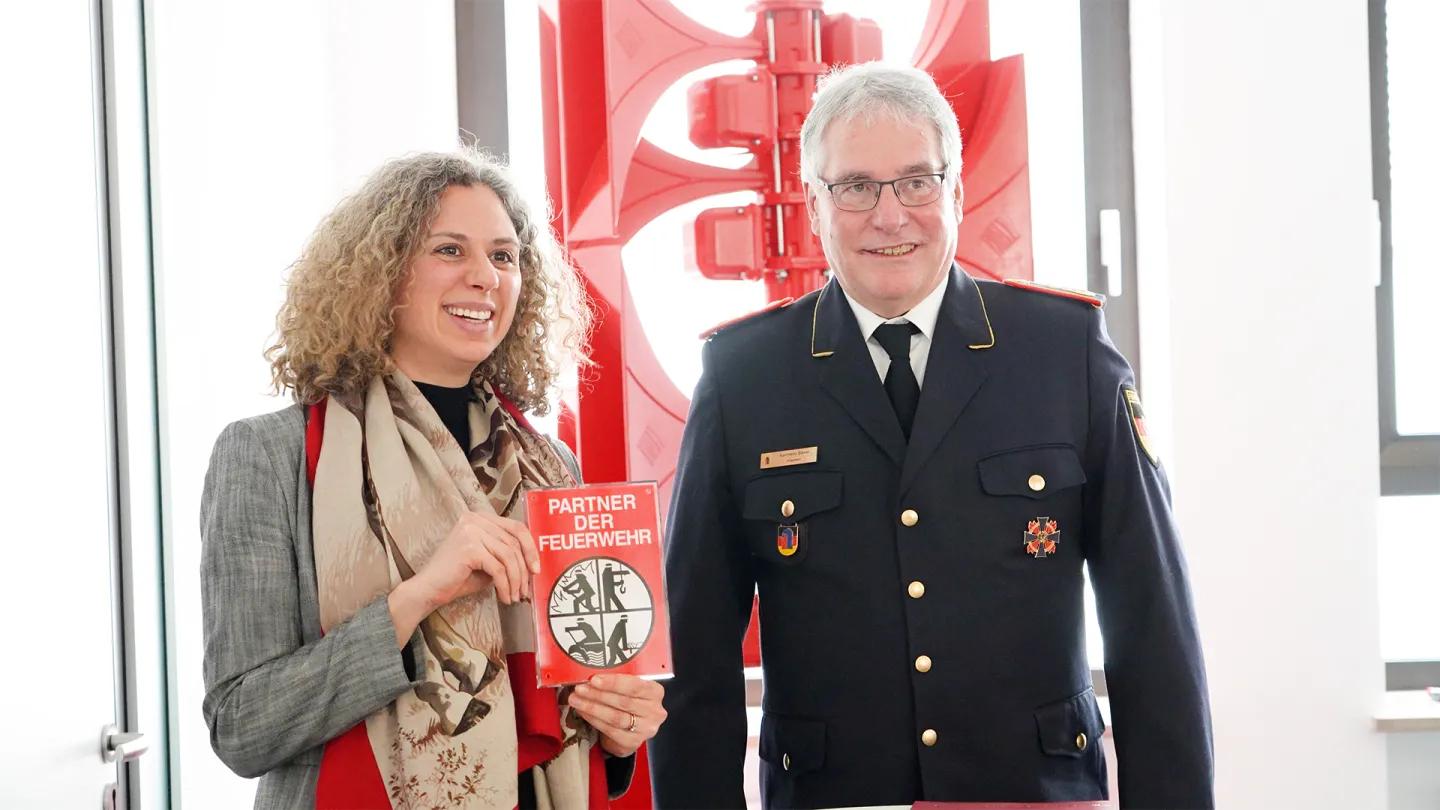 Anna Hörmann erhält von Karl-Heinz Banse, DFV, das Förderschild Partner der Feuerwehr